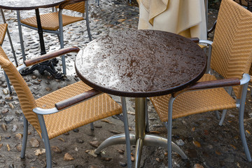 Street cafe tables and chairs after rain.