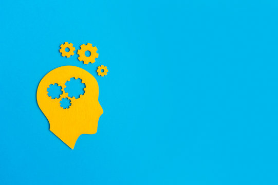 Brain works concept. Thinking, creativity concept of the human head with gears on blue background