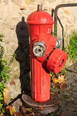 Red fire hydrant near the stone wall of the house