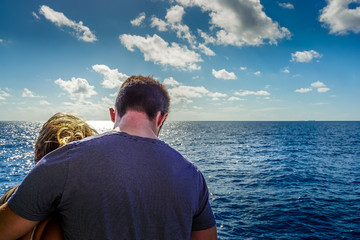 Fototapeta premium A young couple standing together on a boat and admiring the beautiful view.