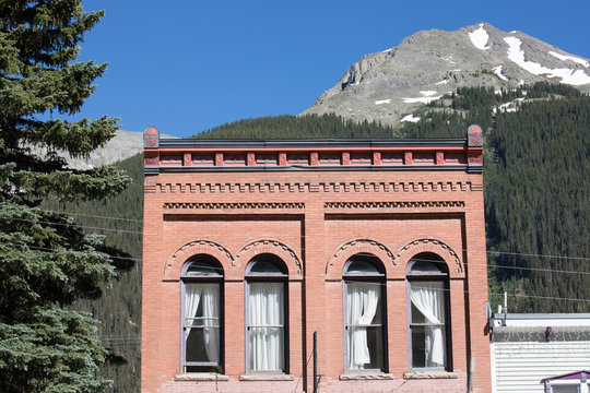 Old brick building against mountains with arched windows