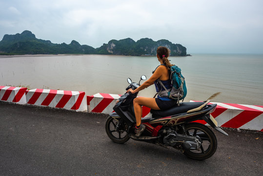 Exploring Vietnam Cat Ba Island Girl Backpacker on a Scooter looks at Ha long Bay