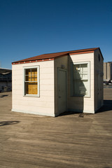 Small wooden guardhouse on New York city dock against clear blue sky
