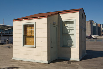  Small wooden guardhouse on New York city dock against clear blue sky