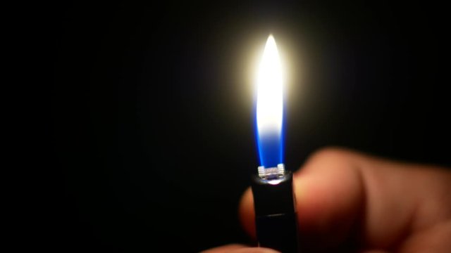 Flame lighters in the hand. Fire in the dark