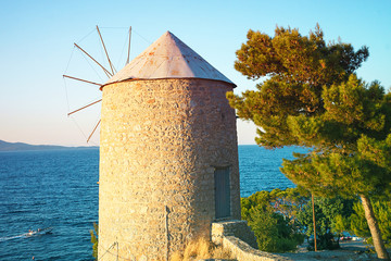 Beautiful view on old wind mill and sea on island Hydra, Greece on sunset time.