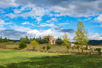 Fototapeta na wymiar Village house on field hill amid massive clouds. Carcassonne. France. 26 nov 2019