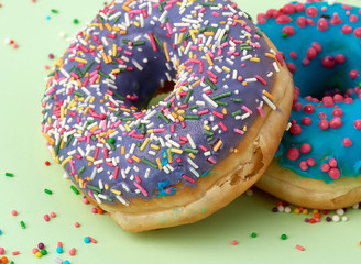 round baked donut with colored sugar sprinkles and with blue sugar icing