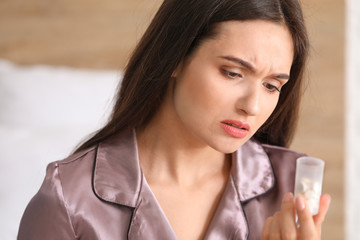 Young woman with pills at home