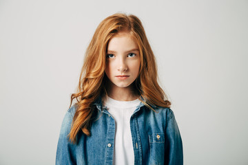 The red-haired teen girl is very offended by her parents. She is angry and look at the camera....