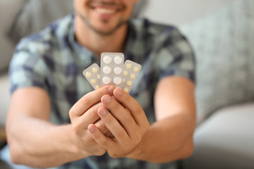 Man with pills at home, closeup