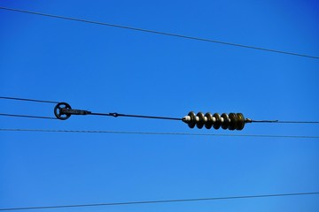 Electrical wires against the blue sky