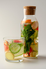Bottles of fresh detox water on white background
