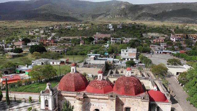 Beautiful Church San pablo villa de mitla with red roof and mountain view in Oaxaca Mexico. Aerial drone view. flying forward..