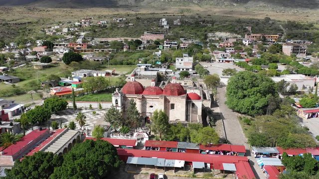 Panoramic view on Mitla Oaxaca in Mexico. Beautiful Catholic Temple San pablo villa de mitla with beautiful red rood and pyramid complex in Oaxaca Mexico. Aerial drone view. flying forward..