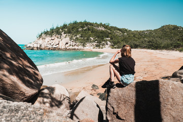 Young girl resting on the beautiful tropical beach covered in sun light, enjoying life