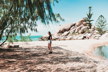 Young girl resting on the beautiful tropical beach covered in sun light, enjoying life