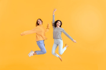 Fototapeta na wymiar Jumping women on color background