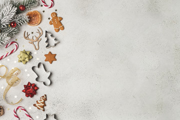 Fototapeta na wymiar Christmas composition flat lay, fir tree, gingerbread, cookie cutter, candy cane, dried orange, ornaments