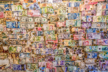 An  assortment money currencies stuck on a wall