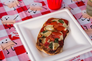 Glamping Pizza on Paper Plate and Checkered Tablecloth