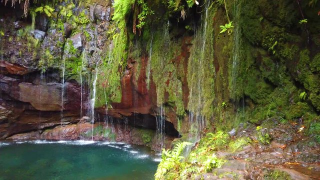 4K video of Big waterfall in the final point of popular hiking route levada 25 fontes. Rabacal, Madeira island, Portugal. There are 25 small waterfalls in one lake. It is amazing and beautiful place.