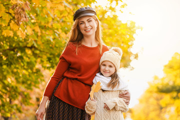 Portrait of happy mother and little daughter in autumn park