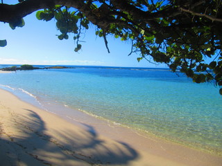 Une plage de sable blanc et la mer turquoise sous un ciel bleu