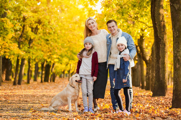 Fototapeta premium Happy family with dog in autumn park