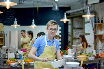 Happy group of friends cooking and talking in the kitchen. Culinary, food and people, cooking class concept/Cooking class. young happy friends in the kitchen