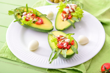 Plate with tasty stuffed avocado on table