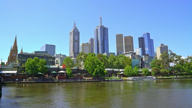 Look over the Yarra river with people walking at the quay in the center of Melbourne