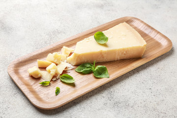 Plate with tasty Parmesan cheese on grey background