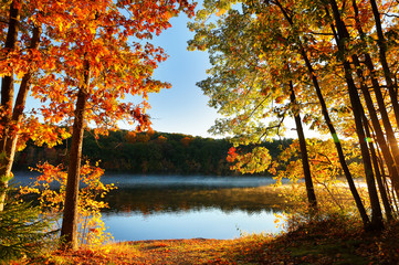 Panele Szklane  Piękny wschód słońca nad jeziorem z liści jesienią na pierwszym planie, Boston Massachusetts.