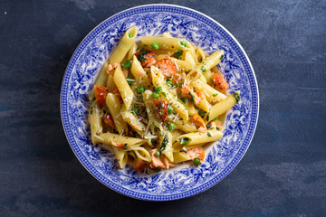 Creamy salmon penne pasta with green peas. View from above, top