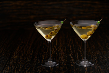 Two martini cocktails with green olives