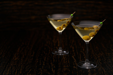 Two martini cocktails with green olives