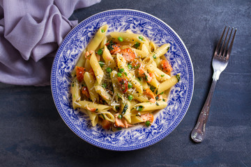 Creamy salmon penne pasta with green peas. View from above, top