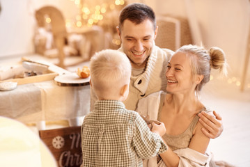 a young family dad, mom and their little son have a fun playing and cooking in the kitchen