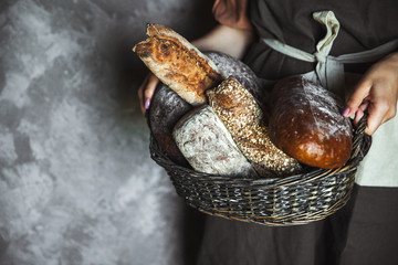 French baguettes in female hands on a black background. homemade baking