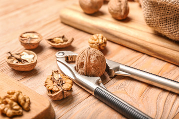 Fototapeta na wymiar Nutcracker with tasty walnuts on wooden background