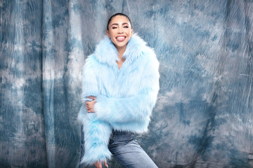 Beauty portrait of smiling young brunette girl wearing blue eco fur. Attractive woman in delicate...