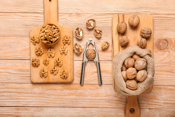 Nutcracker with tasty walnuts on wooden background