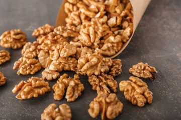 Paper cone with tasty walnuts on dark background
