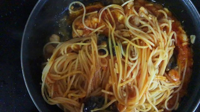 Chef cooking spaghetti seafood sauce. Prawns and mussels roasted on frying grill pan with garlic, parsley, white wine, cayenne, green sauce, lemon on in frying pan. Slow motion.