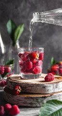 Strawberries in water on a dark gray background. Healthy food. A bouquet of flowers as decoration