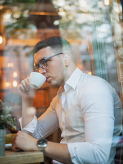 Intelligent young man drinking coffee