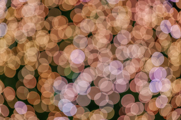 Gold pink Christmas light shiny abstract round bokeh on dark background. Colourful Glitter bokeh from blurry decoration bulbs.