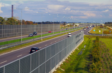 A fragment of the highway protected by acoustic screens. Visible departure from the resting place of travelers.