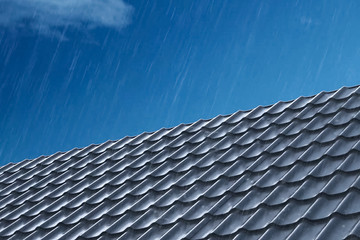 Rain pours on the metal roof tiles of the house. Rain on the roo